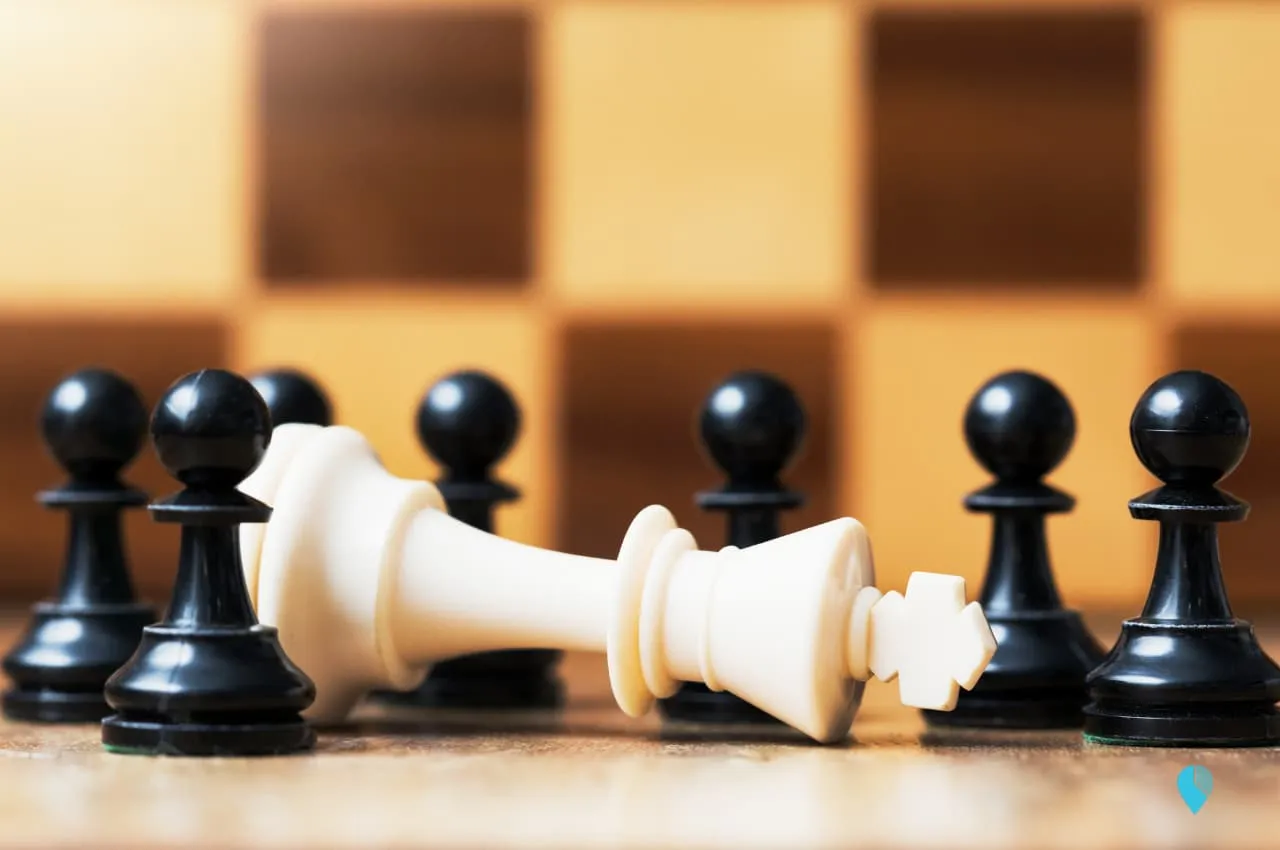 A fallen king on chessboard depecting the implications of misclassifying employees as independent contractor