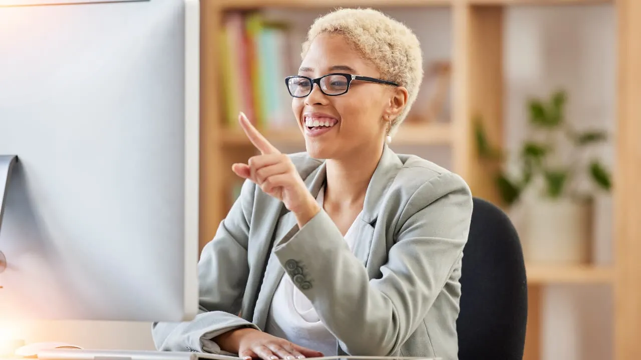 a happy payroll admin looking at a computer monitor