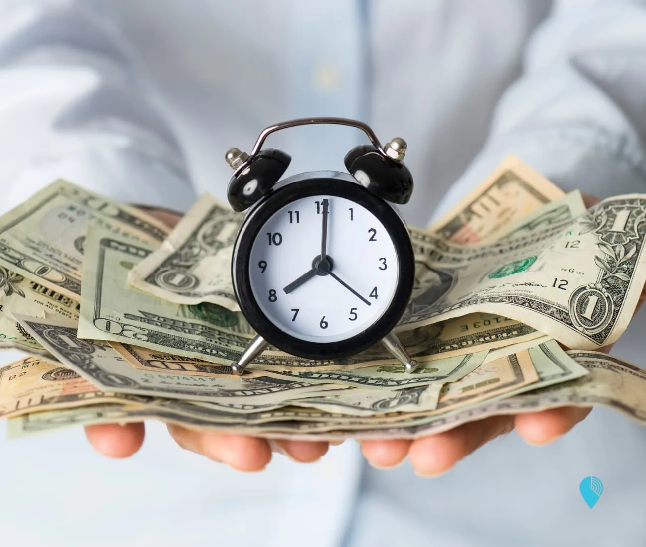 person holding a pile of money with a clock on top representing the high cost of employee time theft
